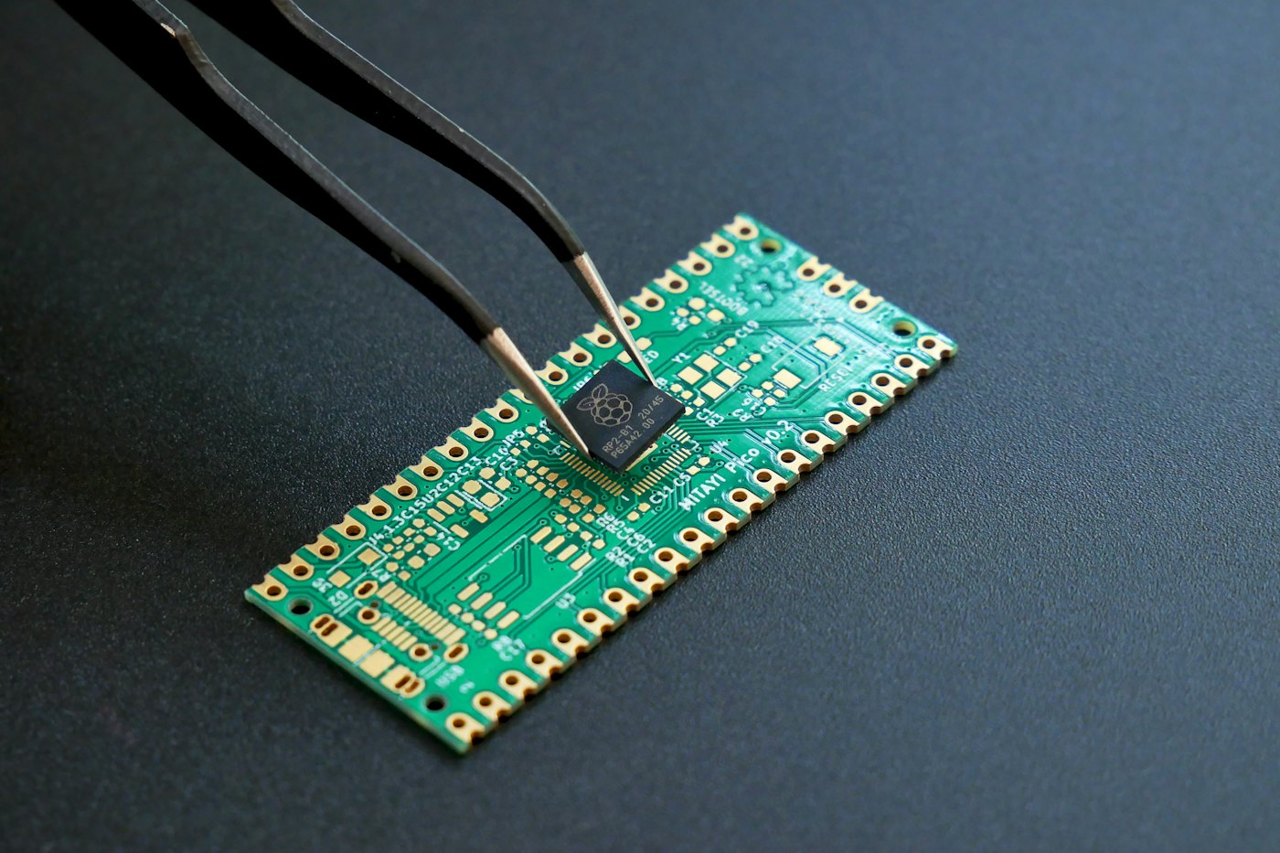 Pinça posicionando um microchip em uma placa de circuito impresso